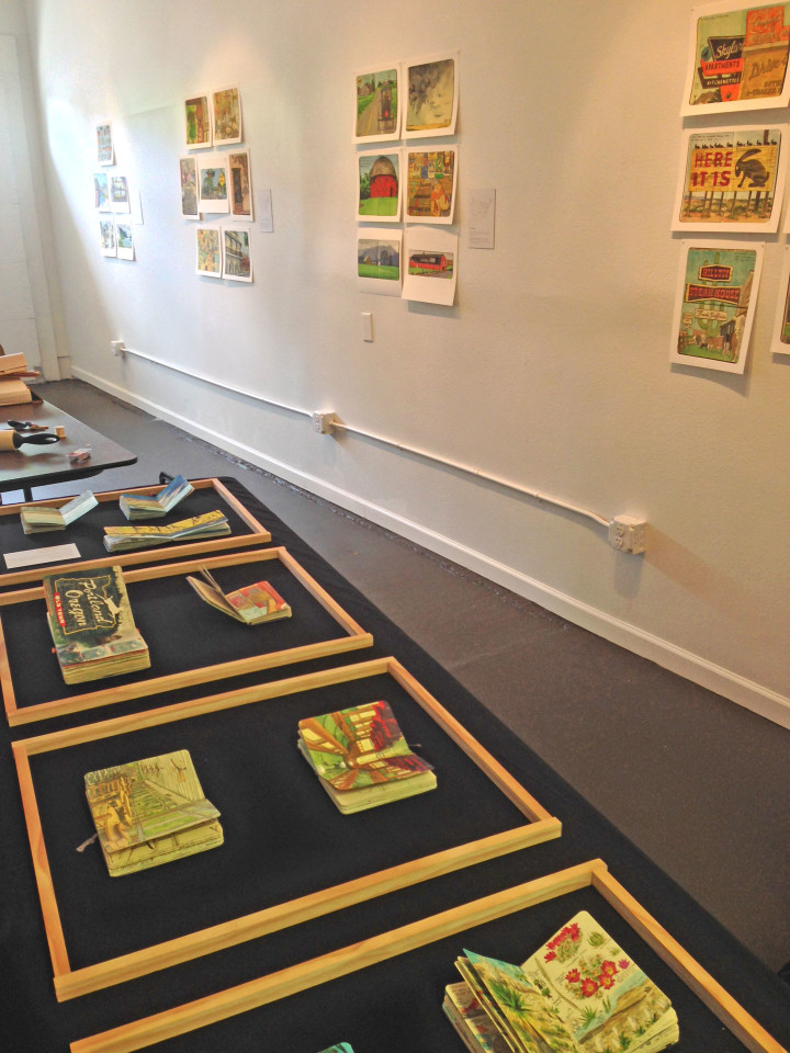 Installation of "Jaunt + Jot" exhibition featuring sketchbook drawings by Chandler O'Leary